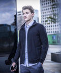 A man wearing the Regatta Professional Pro ultra light fleece stands outdoors in an urban area, holding a mobile, with modern buildings and a glass wall in the background.