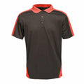 The RG663 by Regatta Professional is a polo shirt in black with red sleeves and side panels, featuring a three-button placket and a collar.
