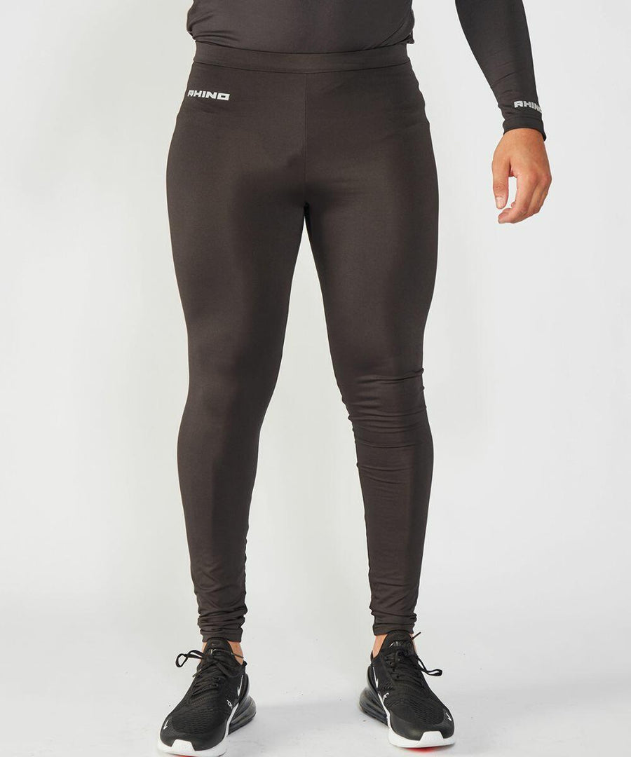 A person wearing Rhino RH011 black compression leggings and black athletic shoes stands against a plain white background.