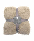 Beige teddy blanket throw measuring 130x170 cm, neatly folded and secured with gray straps, bearing a barcode and the brand name Ribbon.