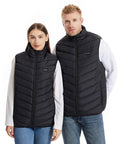 A woman and a man stand side by side against a plain white background, both wearing matching Ribbon Eskimo unisex heated padded bodywarmers over white long-sleeve shirts and blue jeans.