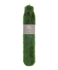 A plush, long green hot water bottle from Hot Water Bottles & Covers, wrapped in soft faux fur. It features a matte grey label around the centre displaying product details and a barcode.