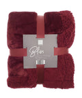 A folded dark red Sherpa winter throw with a soft, plush texture, wrapped in a matching red ribbon. The label displays "Ribbon" as the brand name and specifies the size as 150 x 200 cm.