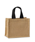 A rectangular, light brown Bags jute tote with black fabric handles stands upright on a white background.