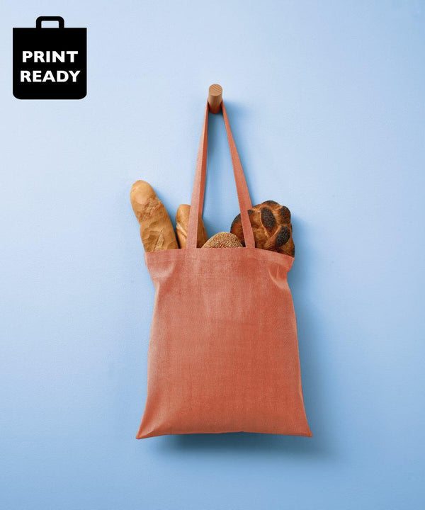 A pink Nutshell RL600 hanging on a wooden peg against a blue wall, filled with different types of bread.