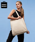 A woman with a ponytail wears a black sleeveless top and holds a plain beige Nutshell RL670 over her shoulder. The background is light blue, and a "Print Ready" label is in the top left corner.