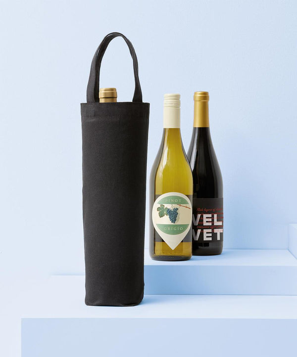 Three wine bottles are shown on light blue steps. One is inside a Nutshell Recycled Premium Canvas Bottle Bag, while the other two—one with a white label and one with a dark label—stand next to each other.