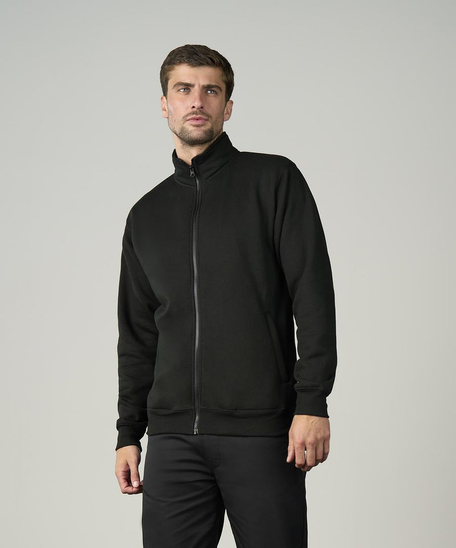 A man with short brown hair and light stubble wears the ProRTX Pro full-zip sweatshirt in black, paired with black trousers, standing against a plain light grey background and looking slightly to the side with a neutral expression.