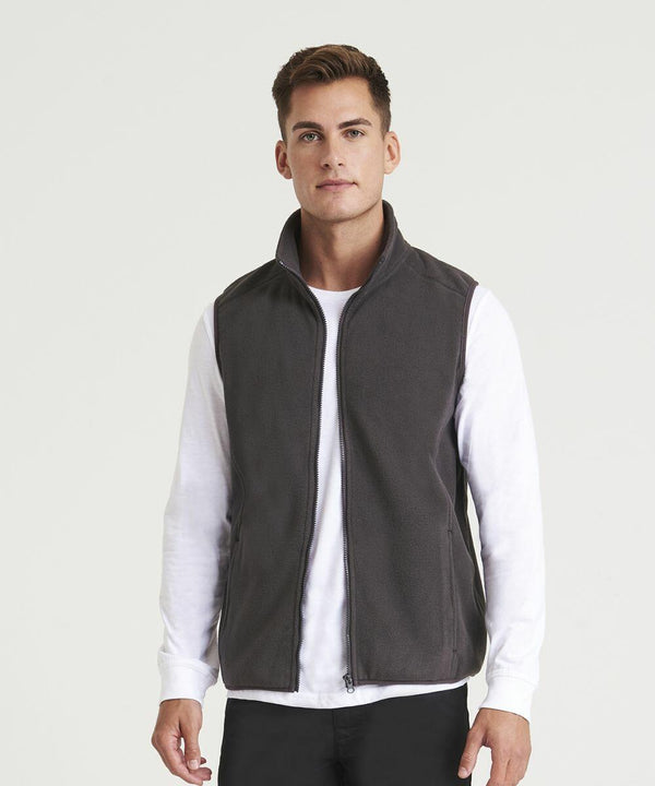 A man stands wearing a dark grey ProRTX RX405 zip-up vest over a white long-sleeve shirt and black pants, facing the camera.