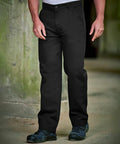 Person wearing ProRTX RX601 black pants and black shoes stands near a greenish wall.