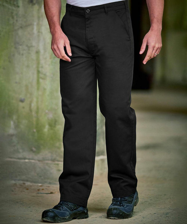Person wearing ProRTX RX601 black pants and black shoes stands near a greenish wall.