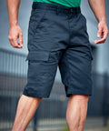 A person wearing dark RX605 cargo shorts from ProRTX and a green shirt stands outdoors with a blurred background.