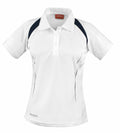 A white short-sleeved polo shirt by Spiro, model S177F, featuring black accents on the shoulders and a buttoned collar with a subtle dotted design on the sides.