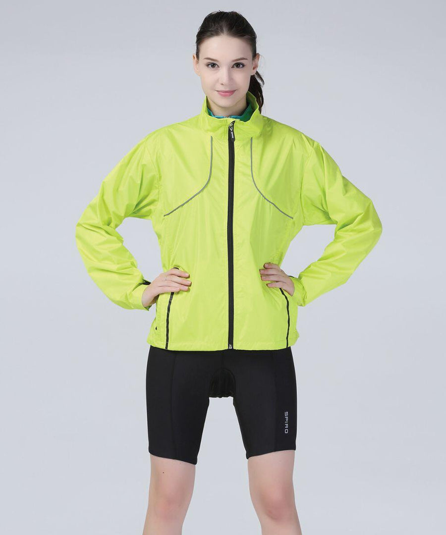 A woman stands against a plain background, wearing a bright yellow Spiro S185X and black cycling shorts.