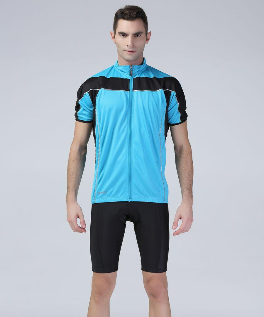 A man stands wearing a blue and black Spiro S188M cycling jersey with black cycling shorts against a plain gray background.