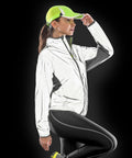 A person wearing a reflective jacket and a neon yellow Spiro S266X adjusts their cap against a dark background.