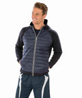 A man wearing a navy blue Spiro S268M zip-up jacket with a hood and dark blue athletic pants stands smiling with his hands in his pockets.