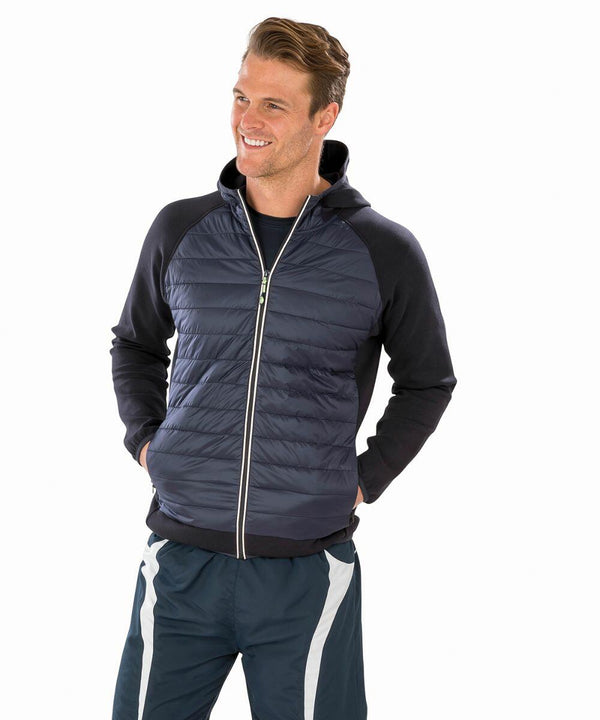 A man wearing a navy blue Spiro S268M zip-up jacket with a hood and dark blue athletic pants stands smiling with his hands in his pockets.