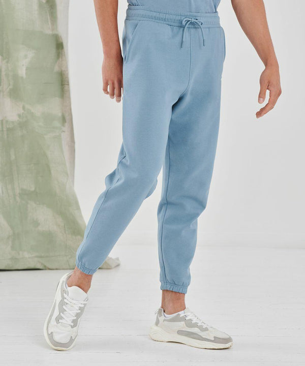 A person wearing light blue joggers and SF white sneakers stands on a white floor with a partially visible green and white backdrop.