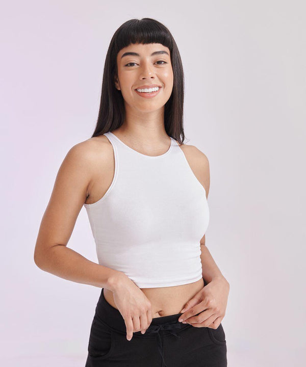 A woman with straight black hair and bangs, wearing a white sleeveless top and black pants, smiles at the camera while holding the SF SK106.