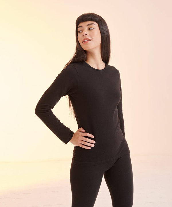 Person stands with one hand on hip, wearing a long-sleeved black shirt and black pants, looking to the left against a light background, showcasing the SF SK124.