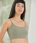 A person wearing an SF SK230 light green cropped camisole top stands in front of a textured green and white background, looking towards the camera.