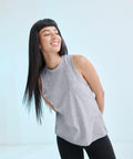 A person with long straight black hair wearing a sleeveless gray top and black leggings smiles while standing in front of a light background, styled with the SF SK232.