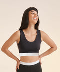 A person with long black hair smiles while looking sideways. They are wearing a black sleeveless top with a white band at the waist from SF, product name SK236.