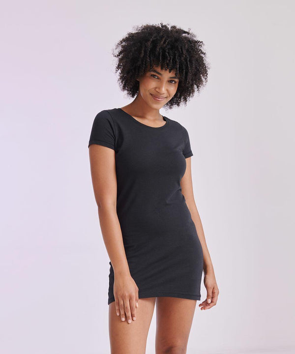 Person with curly hair wearing a black short-sleeved SF SK257 dress stands against a plain background, smiling.
