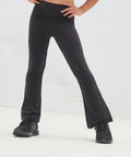 A child models SF Kids flared leggings in black with black trainers, standing hands on hips against a white background. The image is cropped from waist down.