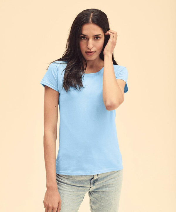 A person with long dark hair wearing a Fruit of the Loom SS050 light blue T-shirt and jeans stands against a plain beige background.