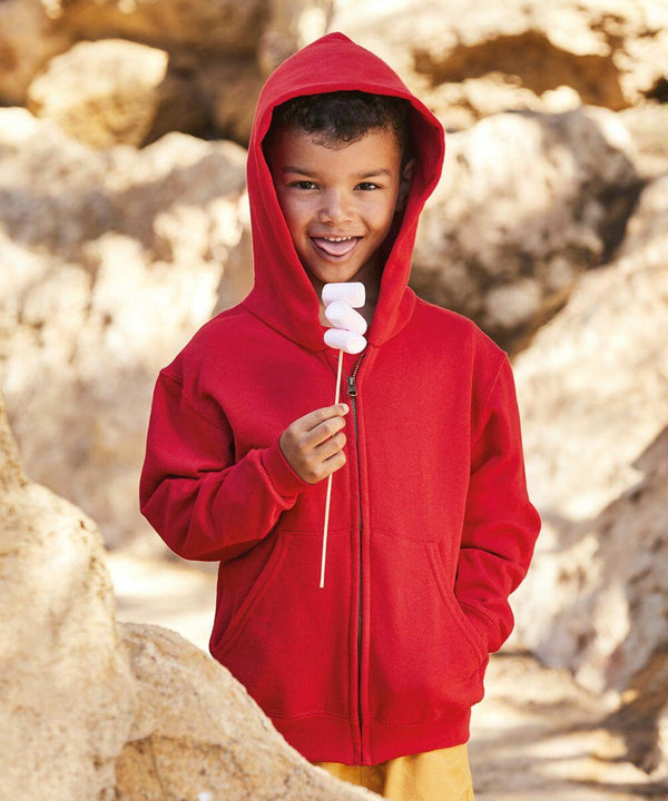 A child wearing a Fruit of the Loom SS225 hooded sweatshirt is holding a stick with three marshmallows, standing in an outdoor rocky area.