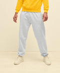 Person in a yellow sweatshirt and light gray SS405 by Fruit of the Loom, standing indoors, showing only the lower half of their body.