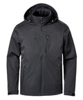 The Softshells jacket is black with a hood, front zip, high collar, and four zipped pockets—two on the chest and two at the waist. It features long sleeves and a minimalist design.