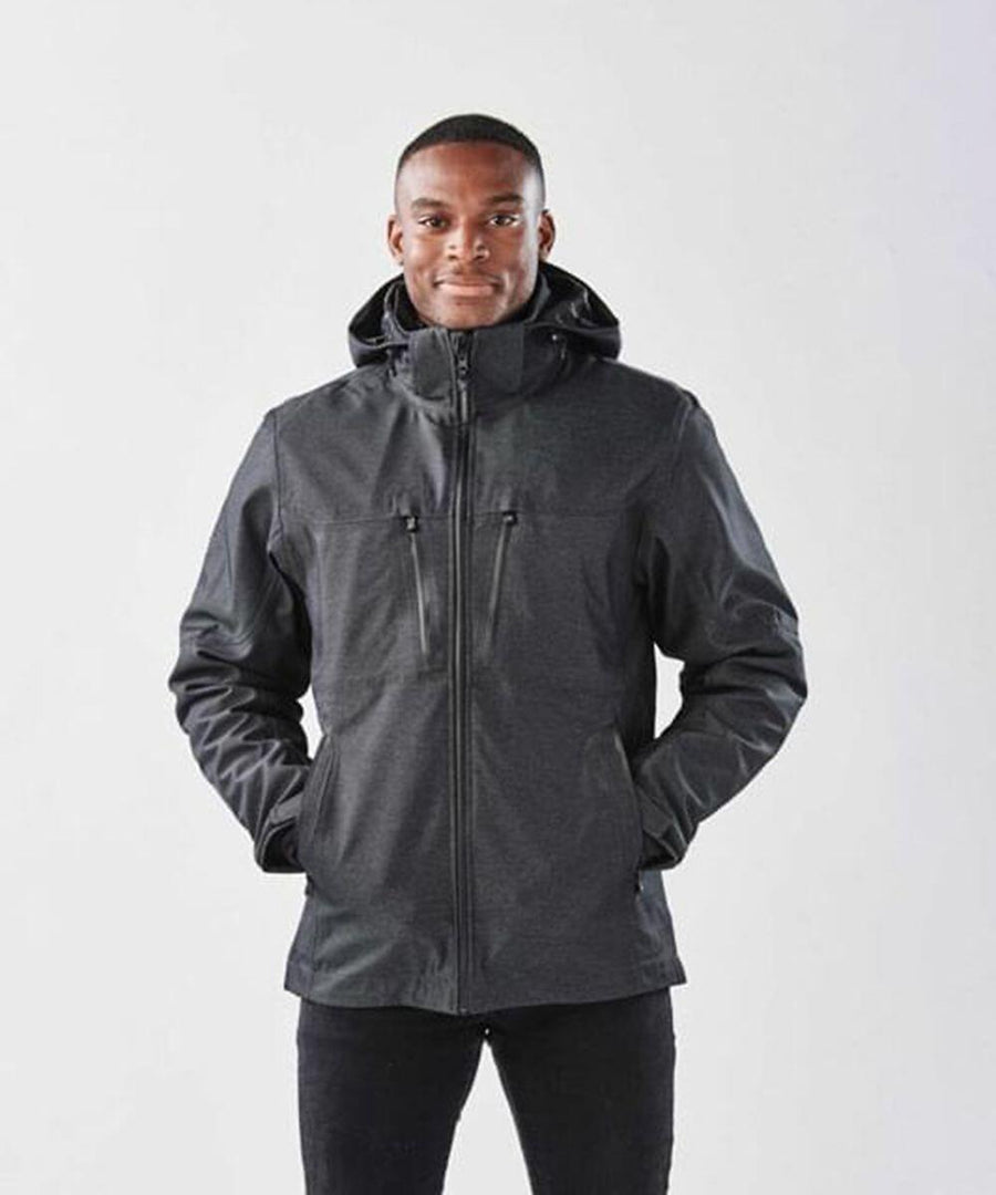 Stormtech ST179 black waterproof jacket with removable inner puffer layer and multiple front zippers, including a main zipper, two vertical chest zippers, and two side pockets. Hooded and long-sleeved design.
