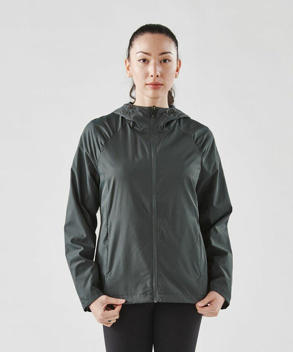 A person wearing a dark green Stormtech ST211 zip-up jacket with a hood stands against a plain background, facing the camera with hands at their sides.