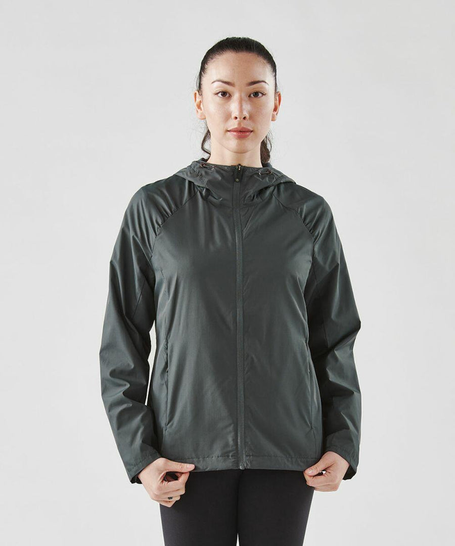 A person wearing a dark green Stormtech ST211 zip-up jacket with a hood stands against a plain background, facing the camera with hands at their sides.