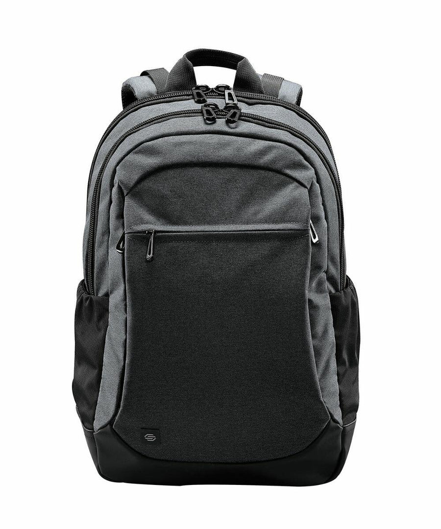 A gray Stormtech ST220 with multiple compartments, black zippers, and a front pocket. It has a handle on top and padded shoulder straps.