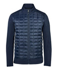 The Softshells jacket features a navy blue quilted front, full zip fastening, stand-up collar, long sleeves, two zipped side pockets, and solid non-quilted fabric on the arms and sides.