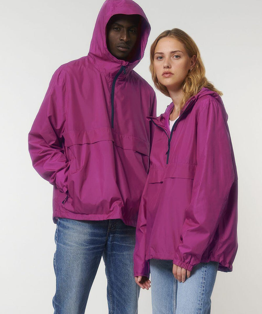A man and a woman wearing Stanley/Stella SX177 magenta hooded jackets and blue jeans stand side by side against a plain background.