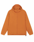 The product, SX179 hooded jacket by Stanley/Stella, is showcased against a white background. This orange jacket features a front zipper and two side pockets. Its simple and lightweight design makes it ideal for casual wear.