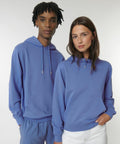 A person with short hair and a person with long hair are both wearing blue Stanley/Stella SX225 hoodies and standing against a plain background.
