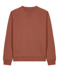 The Sweatshirts product is a solid rust-coloured, long-sleeve crewneck with ribbed cuffs and hem, a subtle stitched V below the neckline, and is displayed flat on a white background.