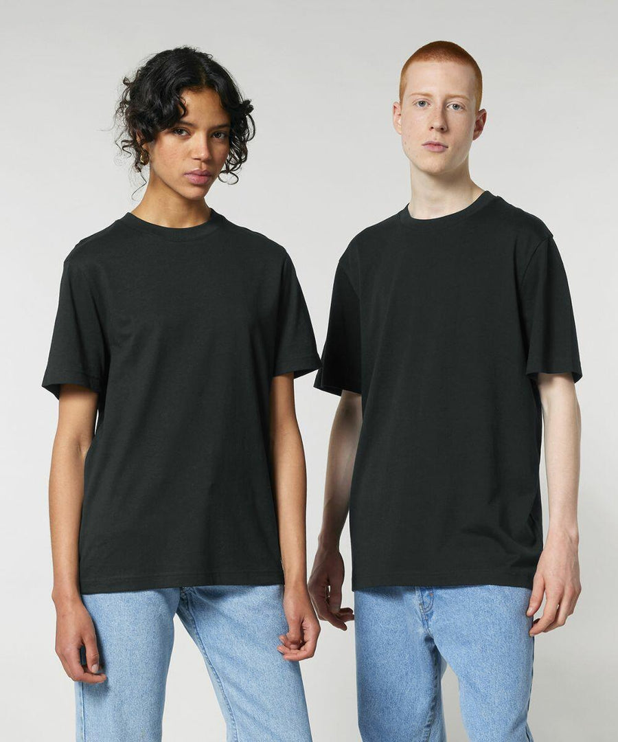 Two individuals, one with curly hair and one with short hair, stand side by side, both wearing Stanley/Stella SX714 black t-shirts and blue jeans against a plain white background.