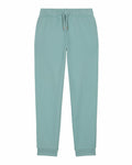 Product SX716 from Stanley/Stella: A pair of light blue-green jogger pants featuring an elastic waistband and drawstring, complete with side pockets and cuffed ankles, laid flat on a white background.