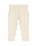 Cream-colored baby pants, identified as SX767 by Stanley/Stella, featuring an elastic waistband and cuffs, are displayed against a white background. The pants showcase a simple, minimalist design.