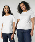 Two women are standing side by side, both wearing Stanley/Stella SX768 white t-shirts and blue jeans, smiling at the camera against a plain background.