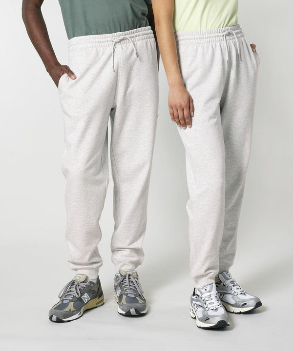 Two individuals standing side by side, each wearing light gray Stanley/Stella SX773 sweatpants and running shoes.