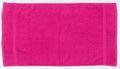 A vibrant Towel City TC003 towel, in a striking pink hue, lies flat against a white background. Its rectangular shape is clearly defined, with visible fabric texture suggesting a soft and absorbent material.