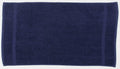 A Towel City TC004 towel, in dark blue, laid flat to reveal its rectangular shape and absorbent texture. Two vertical bands decorate the short edges subtly. The towel is displayed on a plain white background.